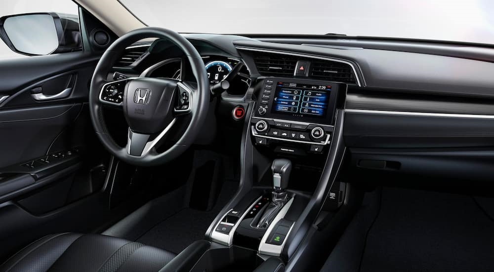 The black interior and steering wheel of a used 2021 Honda Civic for sale.