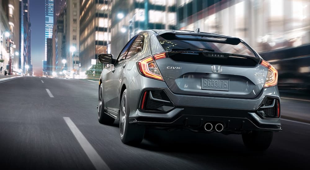 A grey 2020 Honda Civic Hatchback is shown from the rear at an angle.