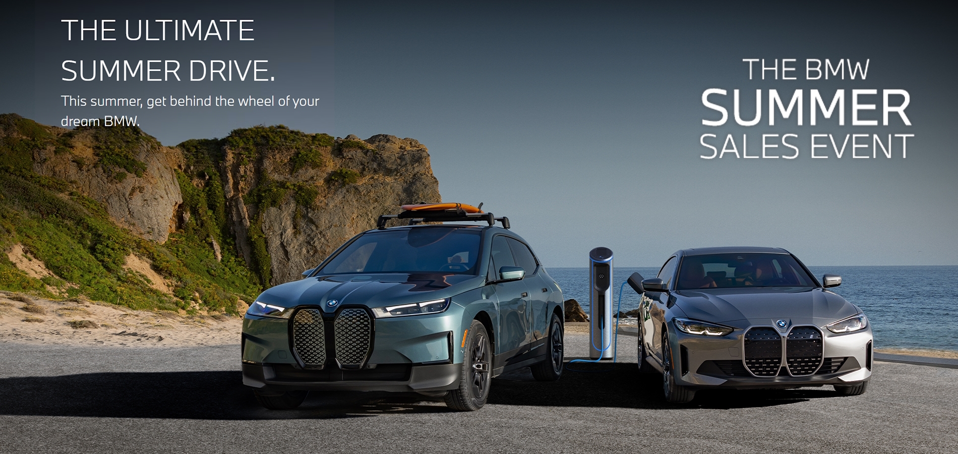 Charging BMW iX and i4 parked in coastal landscape