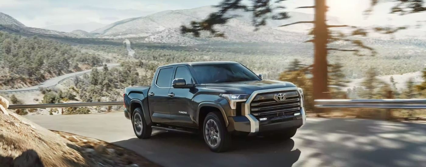 A grey 2024 Toyota Tundra is shown driving on a winding road.