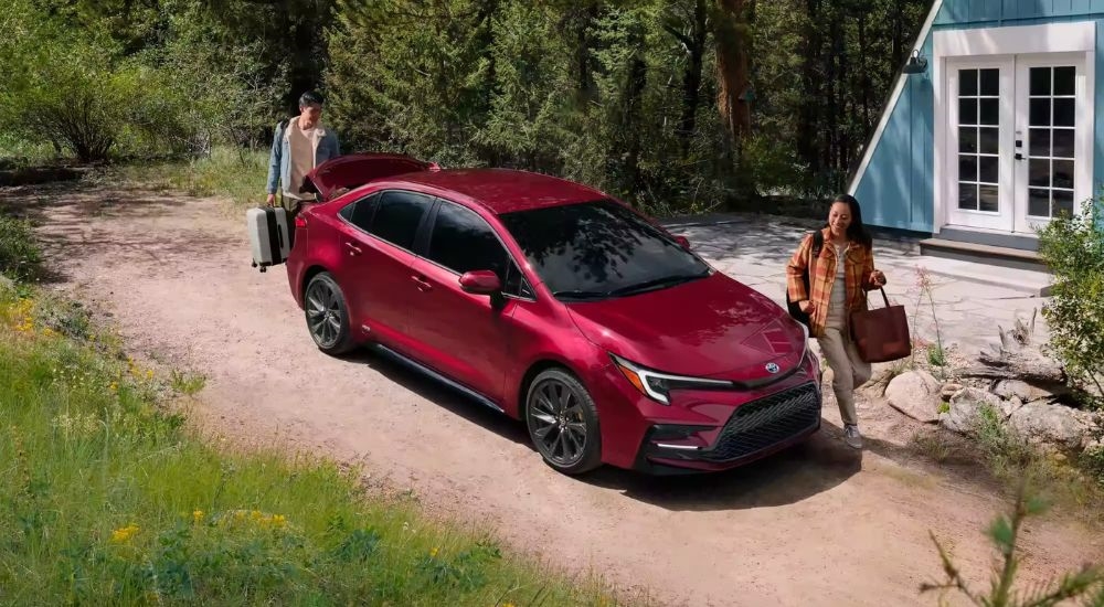 A red 2023 Toyota Corolla Hybrid SE is shown parked in front of an A-frame.