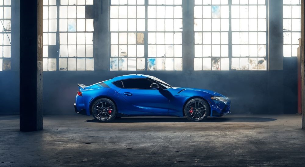 A popular used Toyota for sale, a blue 2022 Toyota GR Supra, is shown parked in a warehouse.