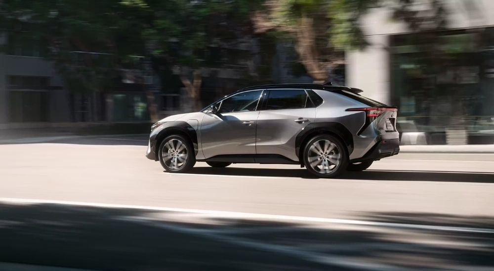 A silver 2023 Toyota bZ4X is shown from the side on a city street.