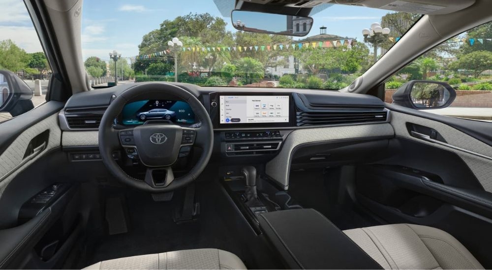 The tan interior of a 2025 Toyota Camry is shown from the driver's seat.