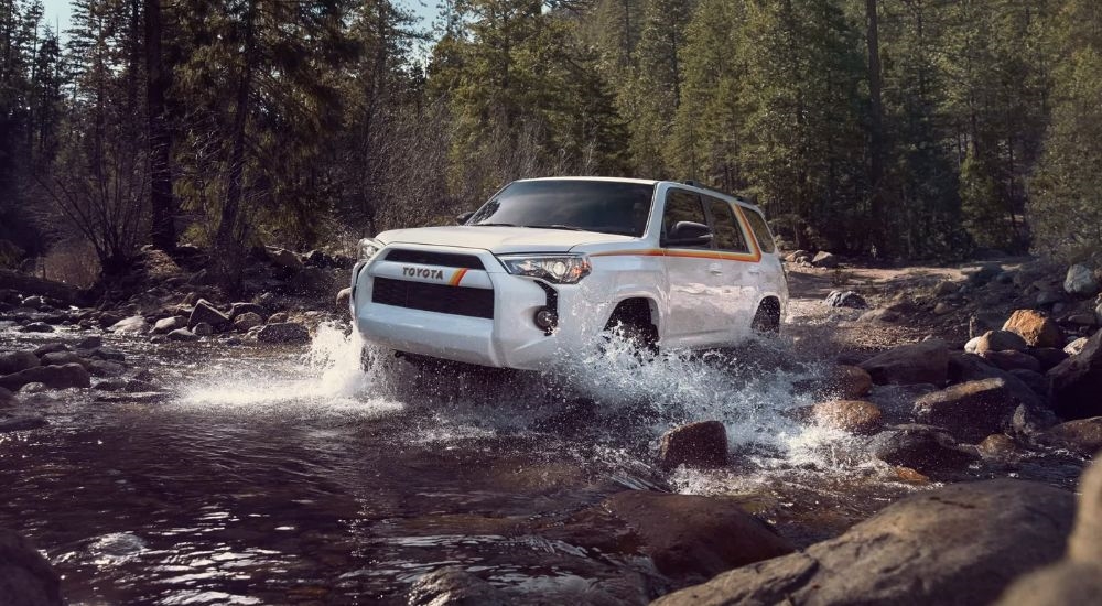 An white 2023 Toyota 4Runner 40th Anniversary is shown splashing through a creek.