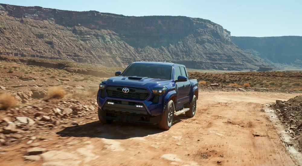 A blue 2024 Toyota Tacoma TRD Sport is shown from the front at an angle.