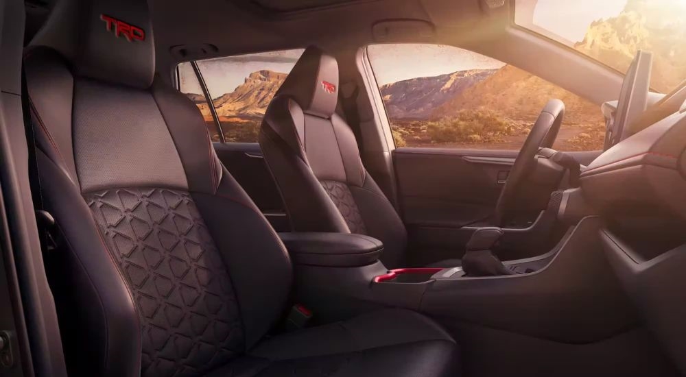 The black interior of a 2024 Toyota RAV4 TRD is shown from the passenger side.