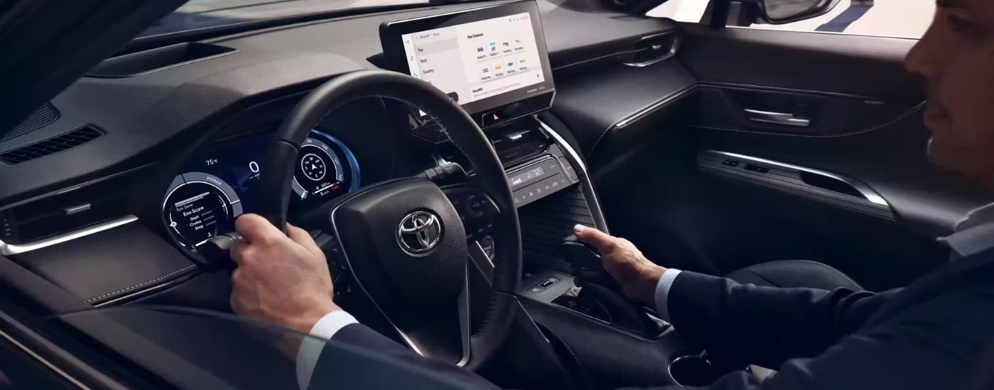 A person is shown driving in 2023 Toyota Venza.