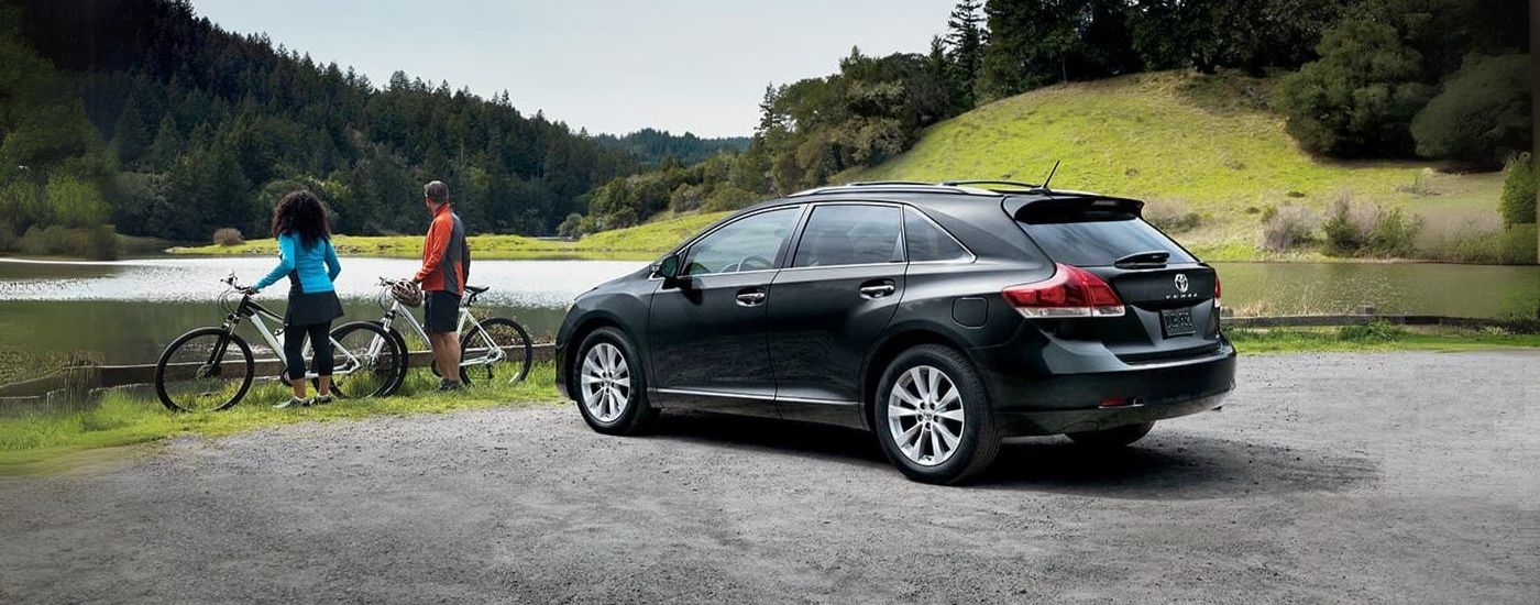 A black 2015 Toyota Venza for sale is shown parked near a lake.