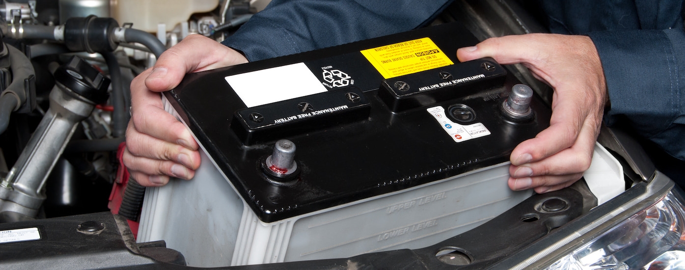 A technician replacing a car's battery.