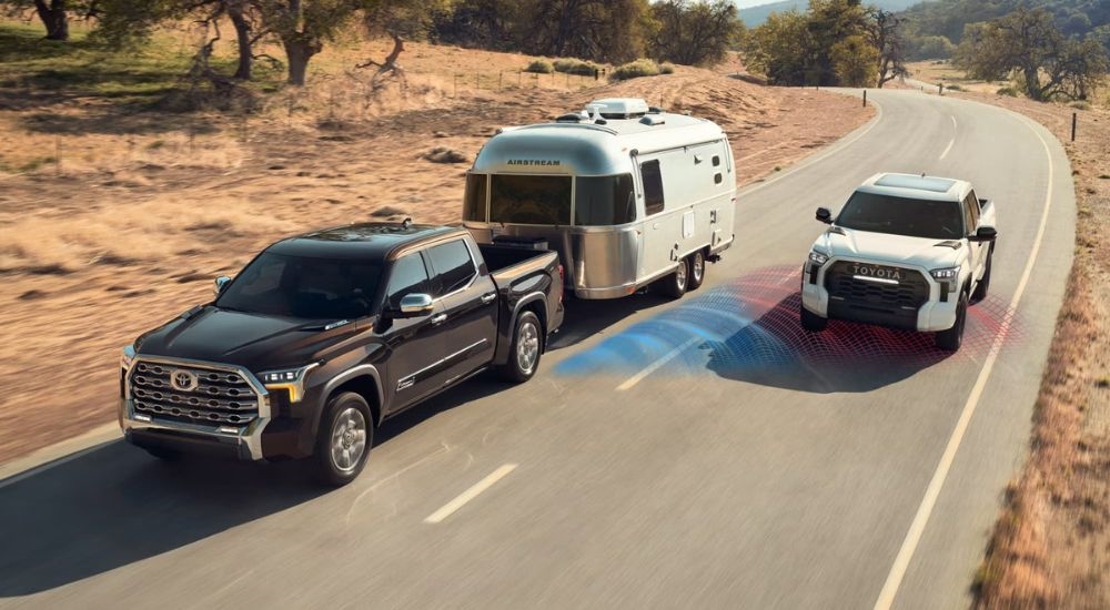 A brown 2024 Toyota Tundra is shown towing an Airstream trailer with simulated sensor lines.