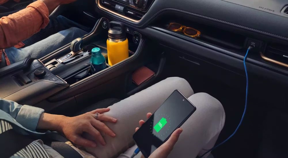 A person is shown charging a phone in a 2024 Toyota Grand Highlander Platinum MAX.