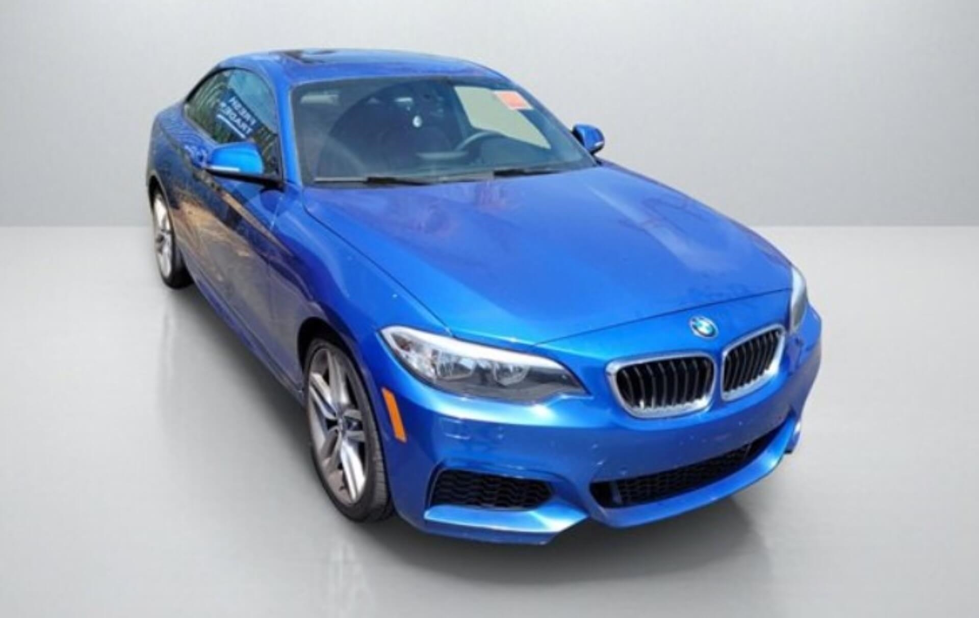 BMW 228i in blue color on grey showroom floor in Chula Vista Honda inventory