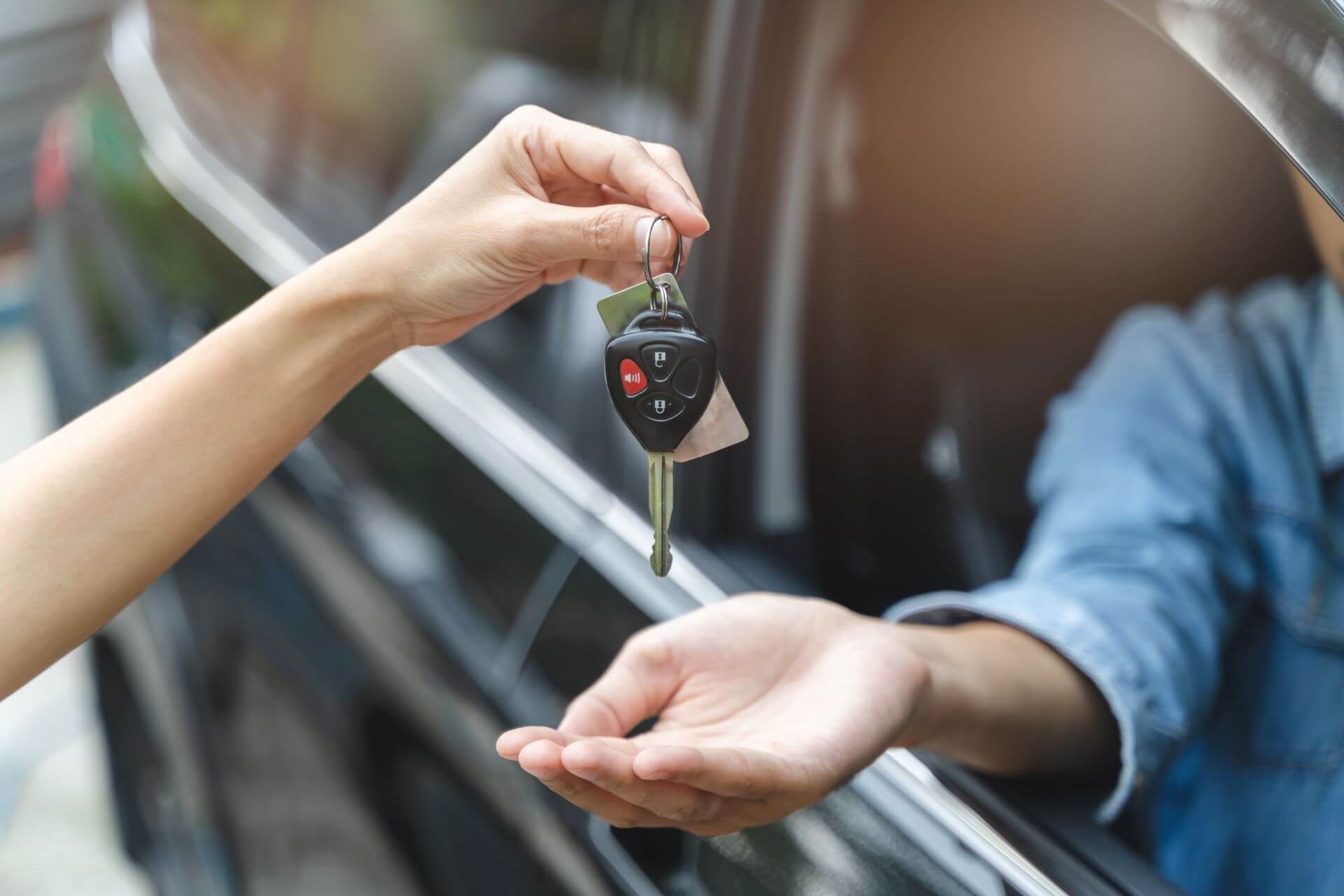 Keys handed to person in used car model at dealership