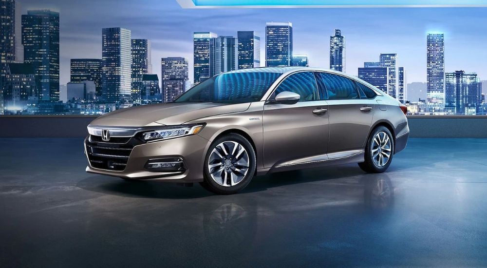 A tan 2018 Honda Accord Hybrid is shown parked neat a city.