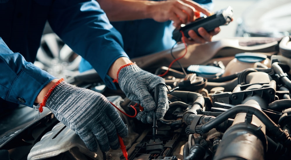 Technicians testing a car's battery during an express service visit.