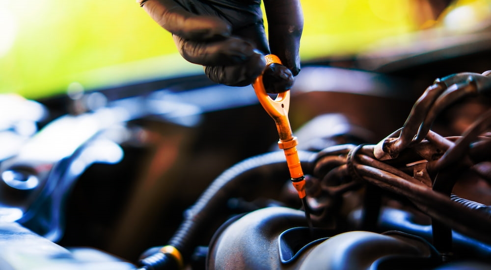 A technician checking engine oil levels with a dipstick.