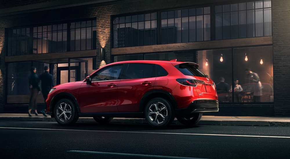 A red 2025 Honda HR-V parked outside a building and angled left.