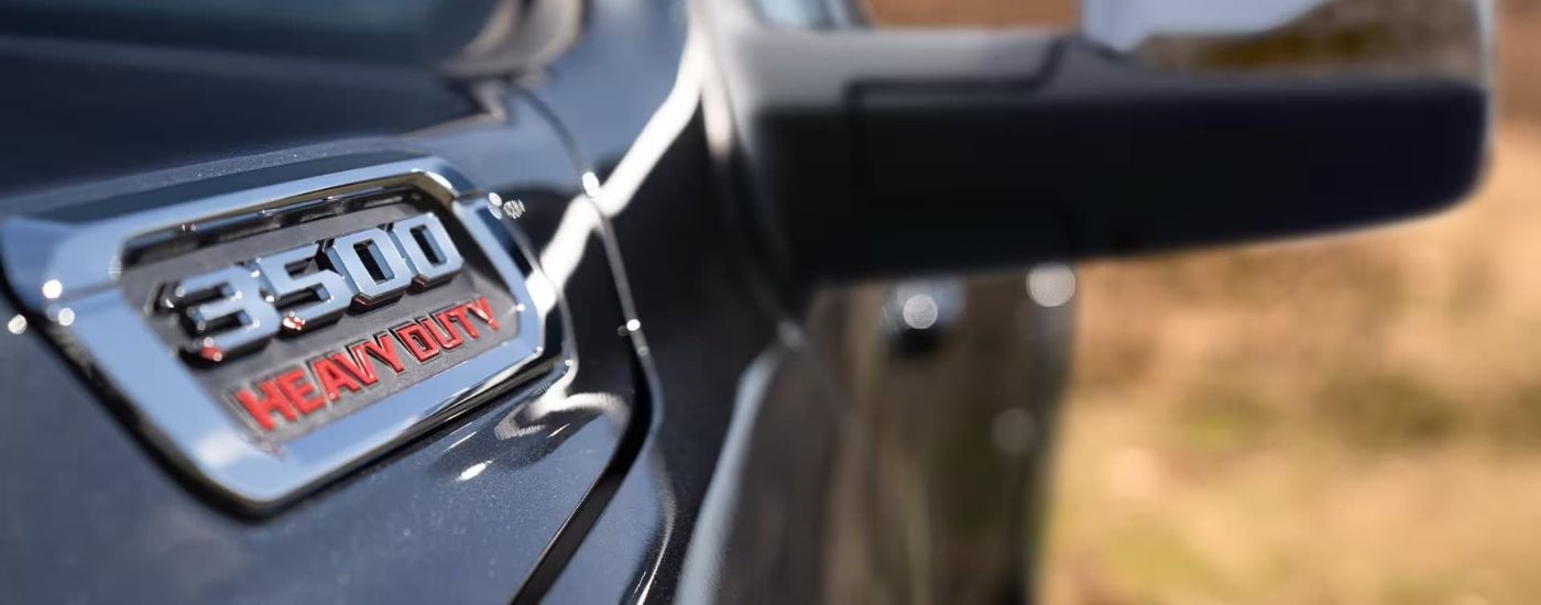 A close up shows a fender badge on a black 2023 Ram 3500.