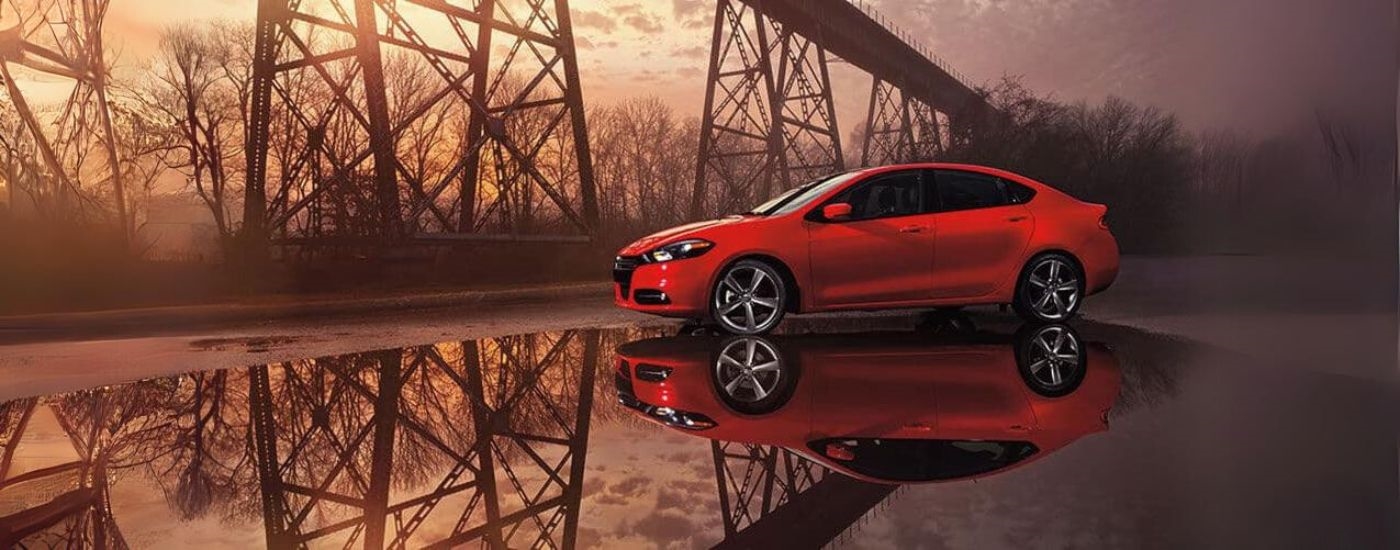 A red 2015 Dodge Dart is shown near a bridge after leaving a Dodge dealer.