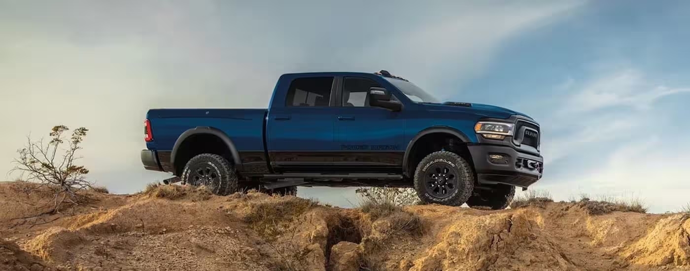 A blue 2024 Ram 2500 Power Wagon is shown from the side while off-road.