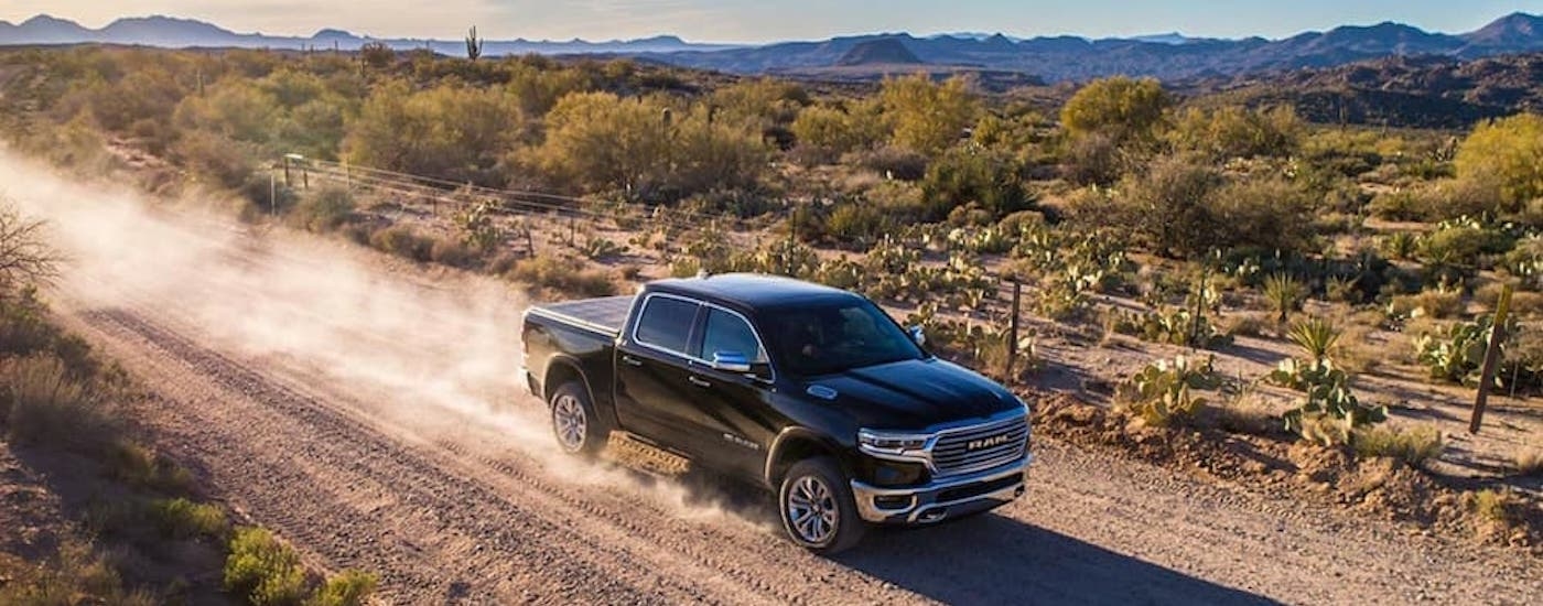 Overhead view of a black 2019 Ram 1500 driving on a dirt road.