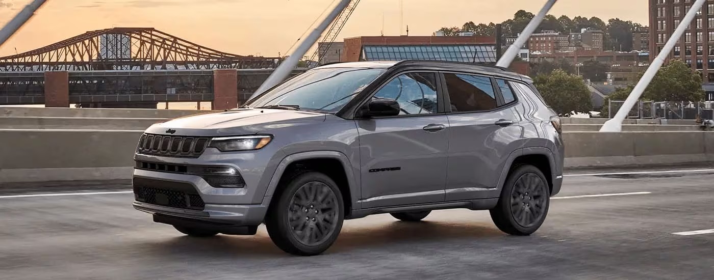 A 2023 Jeep Compass is shown from the side driving on an open highway.