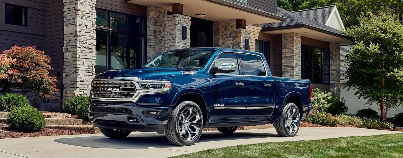 A blue 2023 Ram 1500 is shown parked in a driveway after leaving a Ram dealer near Kingston.