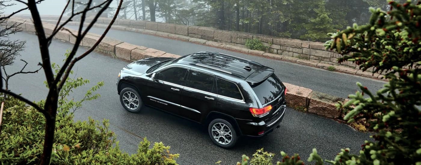 High angle view of a black 2022 Jeep Grand Cherokee WK angled left and driving.