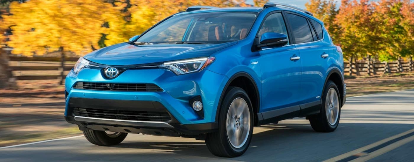 A blue 2016 Toyota RAV4 angled left and driving.