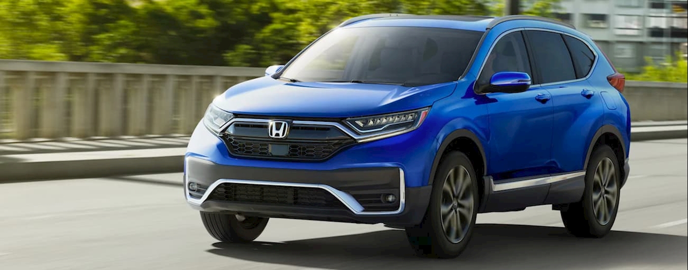 A blue 2021 Honda CR-V Touring driving in the city.