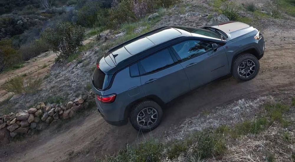 A grey 2024 Jeep Compass Trailhawk is shown off-road.