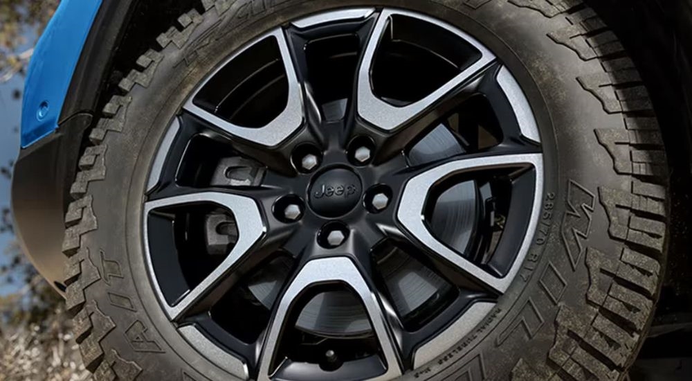 A close-up show a wheel on a blue 2024 Jeep Compass Trailhawk.