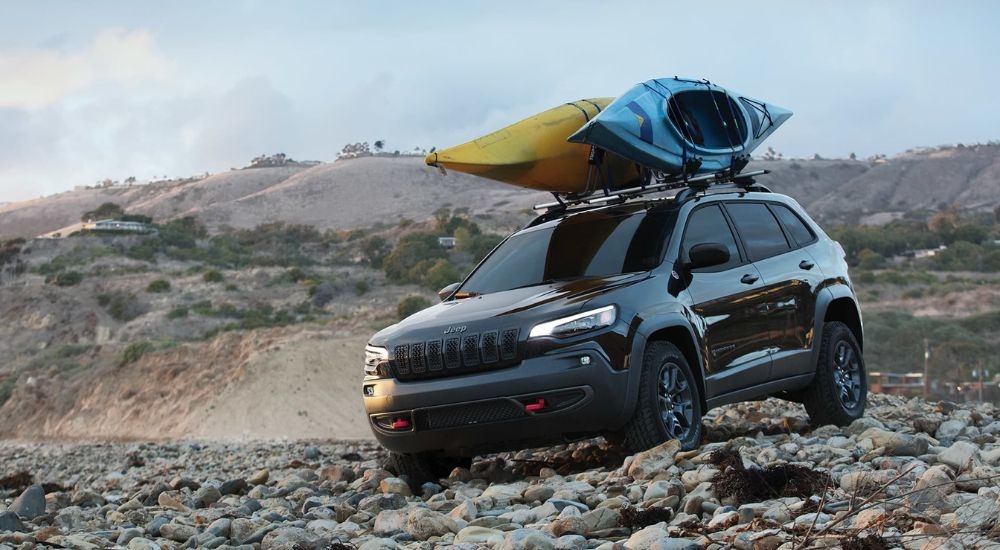 A grey 2020 Jeep Cherokee is shown parked on rocks.