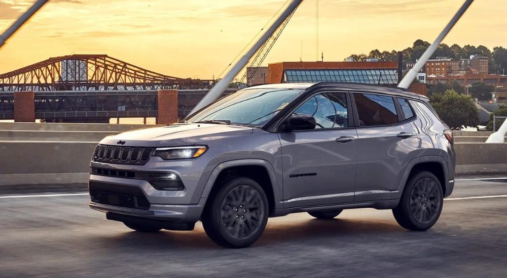 A grey 2022 Jeep Compass is shown driving to a Jeep dealer near you.