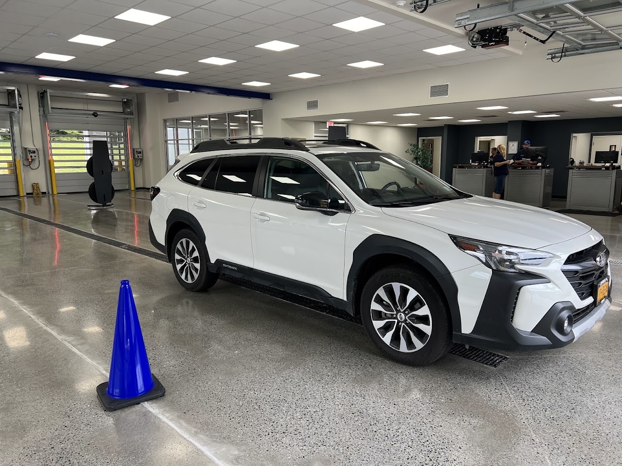 A white Subaru vehicle parked in a Ruge's Subaru's service center.