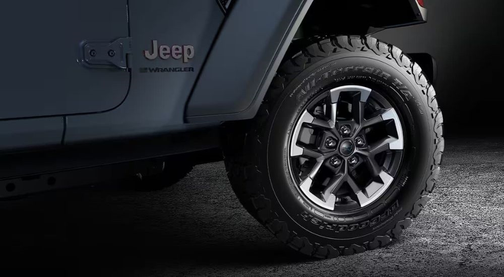 A close up shows a black and silver wheel on a grey 2024 Jeep Wrangler.