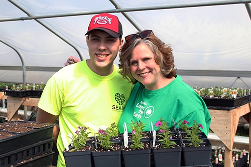 Man and woman holding plants at SEADS Garden Center