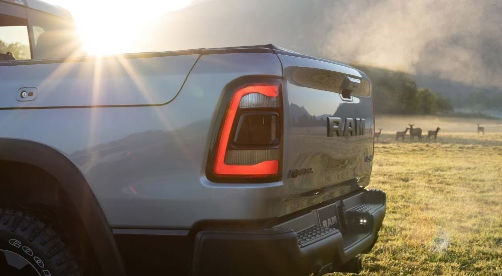 A close-up shows the driver side taillight on a grey 2023 Ram 1500 Rebel.