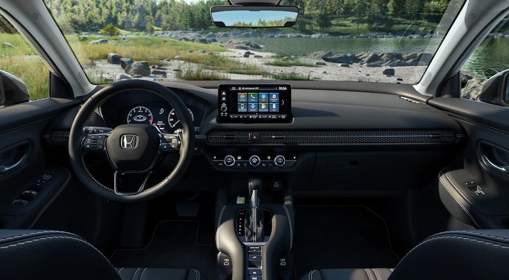 The black interior of a 2024 Honda HR-V EX-L parked near a stream.