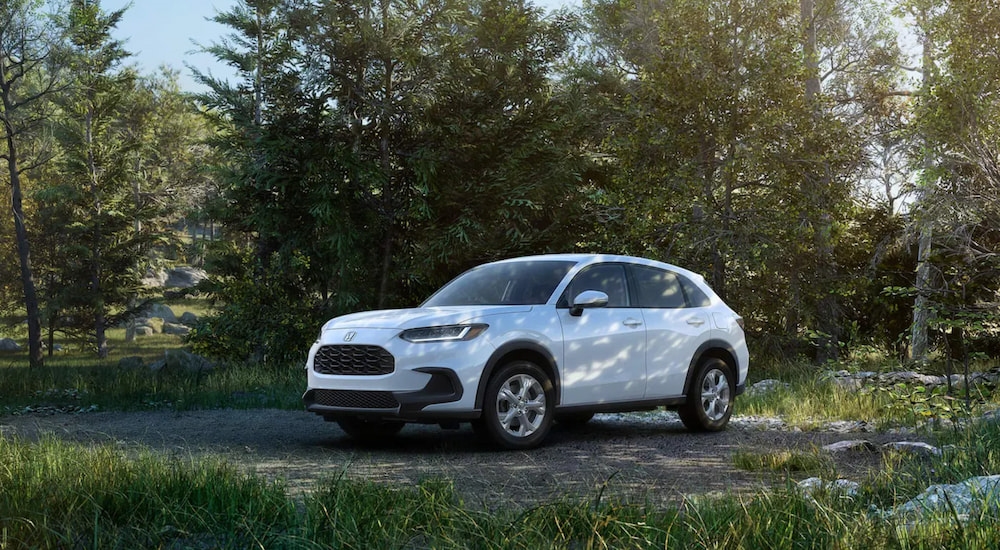 A white 2024 Honda HR-V LX parked off-road in the forest.