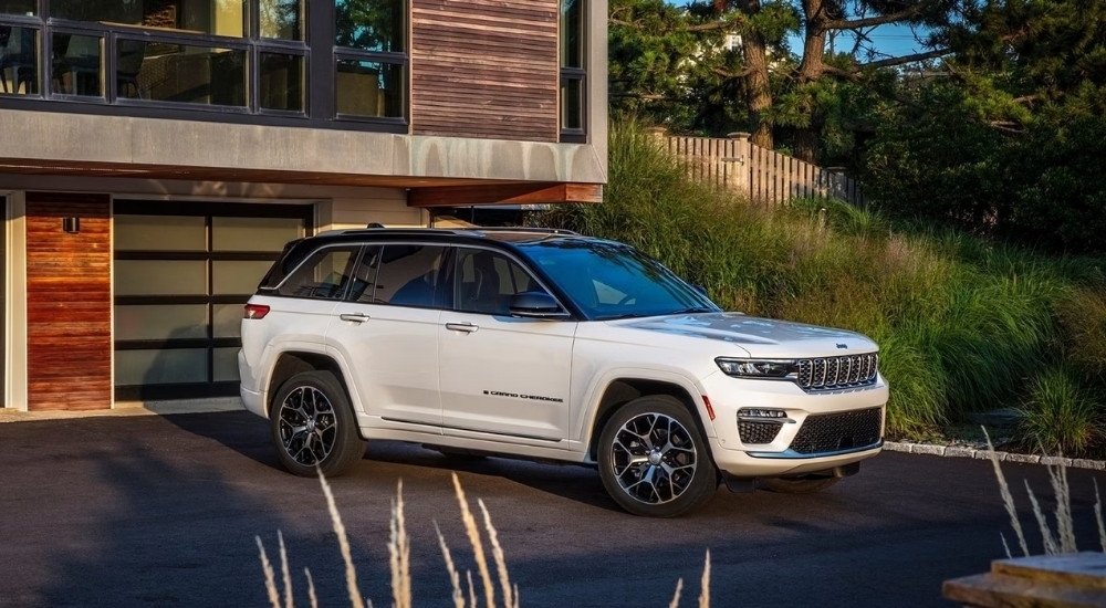 A white 2022 Jeep Grand Cherokee is shown parked in a driveway.