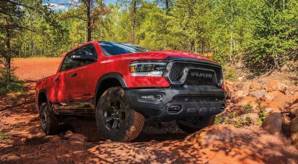 A red 2022 Ram 1500 is shown parked on a rock after leaving a used Ram dealership.