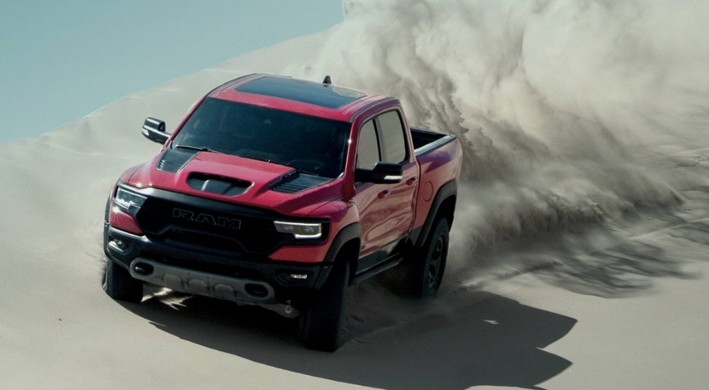 A red 2022 Ram 1500 TRX is shown off-roading in a desert.