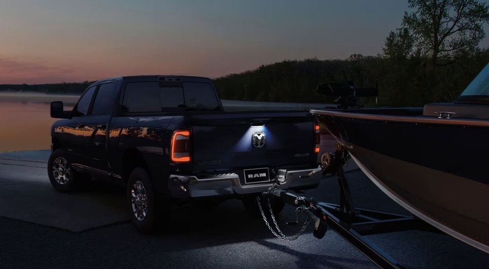 A black 2023 Ram 2500 is shown near a lake at dusk.