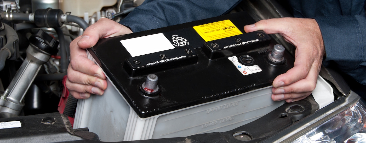 A mechanic replacing a car battery.