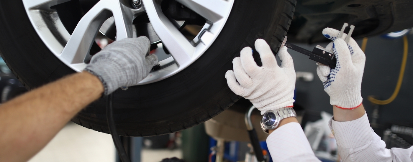 Two mechanics perform a tire inspection.