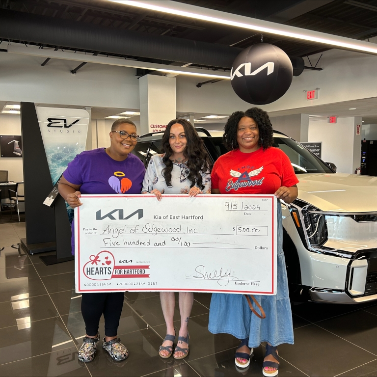 August 2024 Charity winners holding their giant check