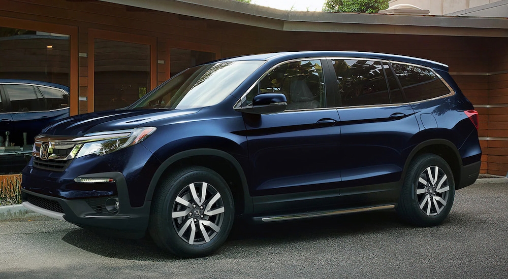 A blue 2022 Honda Pilot EX-L parked in a driveway.