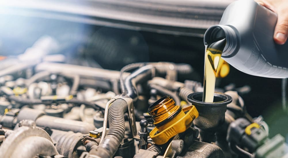 An oil can being poured into an engine.